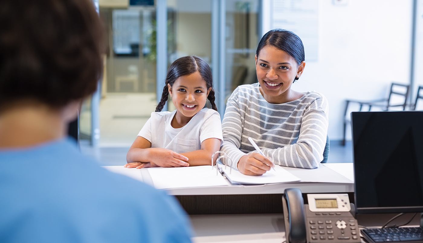 Mother and daughter checking in at dental office front desk