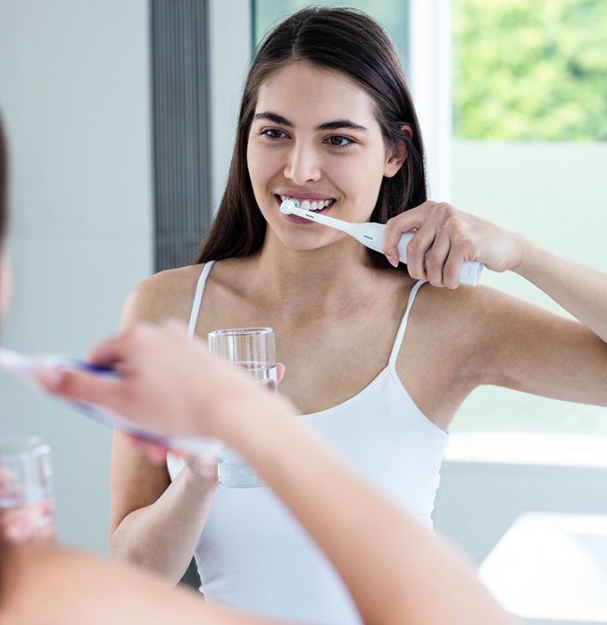 Woman brushing teeth during at home dental hygiene routine