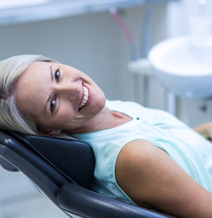 Dental patient smiling after successful implant salvage treatment