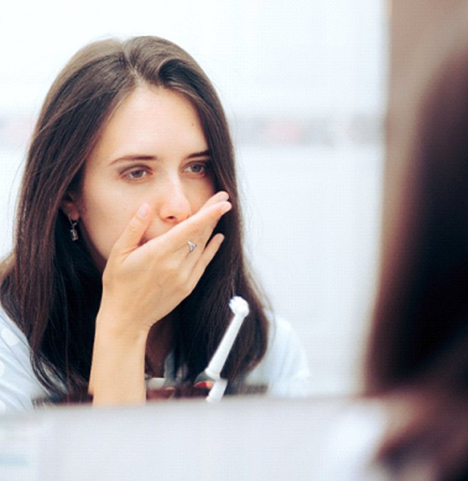 Concerned woman thinking about dental implant failure and salvage in Chelsea