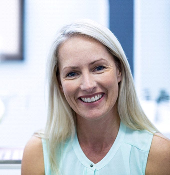 Woman smiling after getting dental implants in Chelsea, MI
