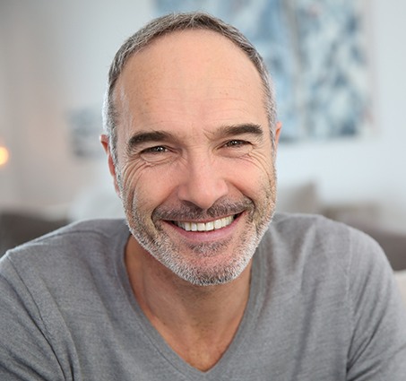 Man smiling after dental implant tooth replacement