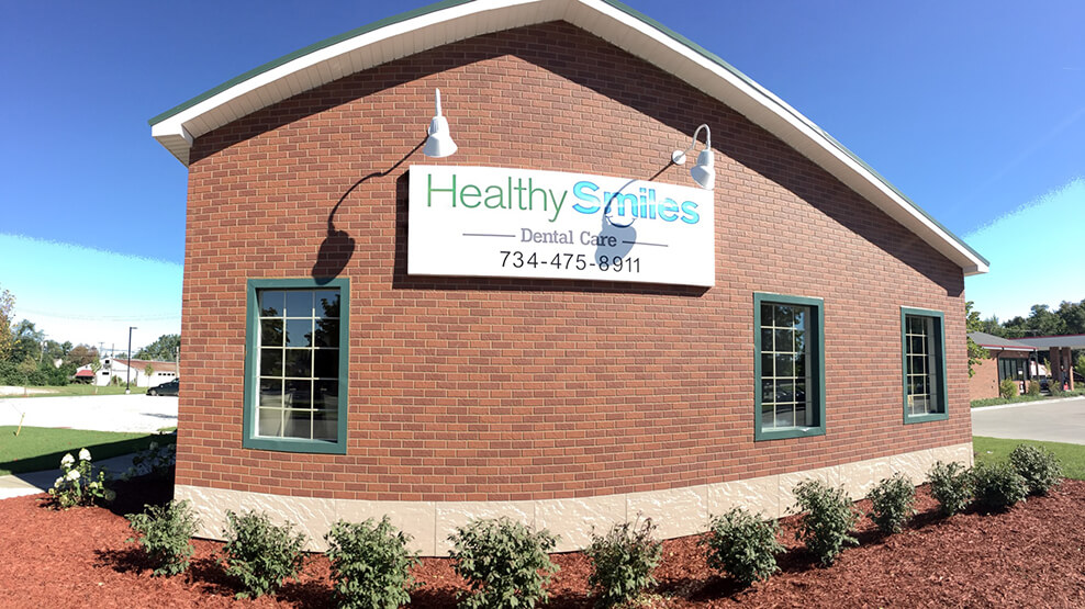 Healthy Smiles Dental Care of Cheslea sign on outside of dental office building