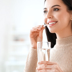 a woman taking an oral conscious sedation pill