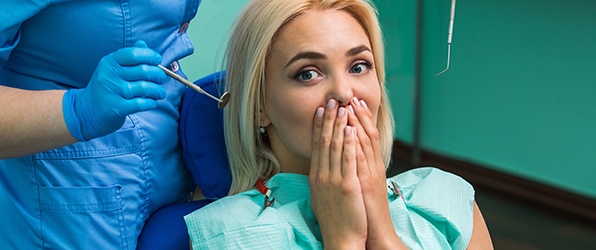 Woman in need of replacement teeth covering her mouth