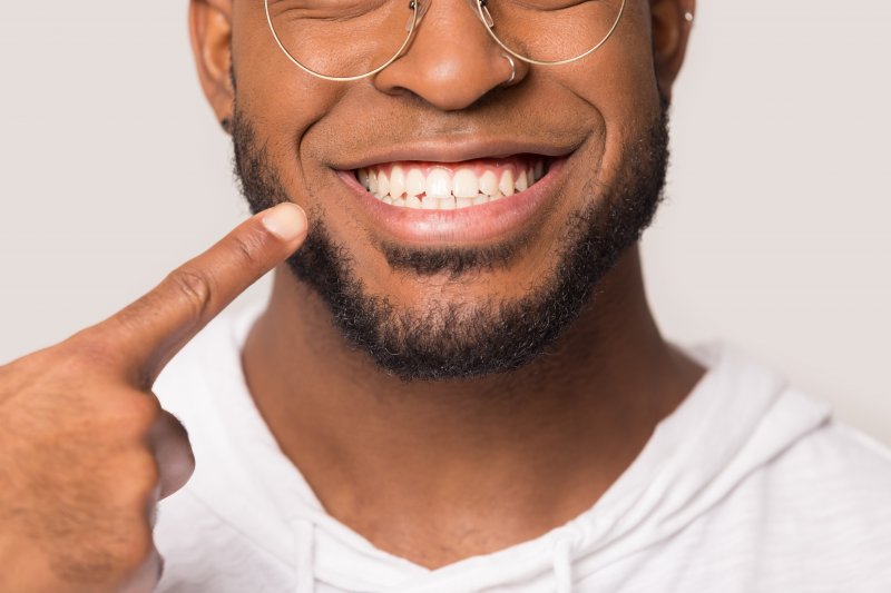 man pointing to his white smile