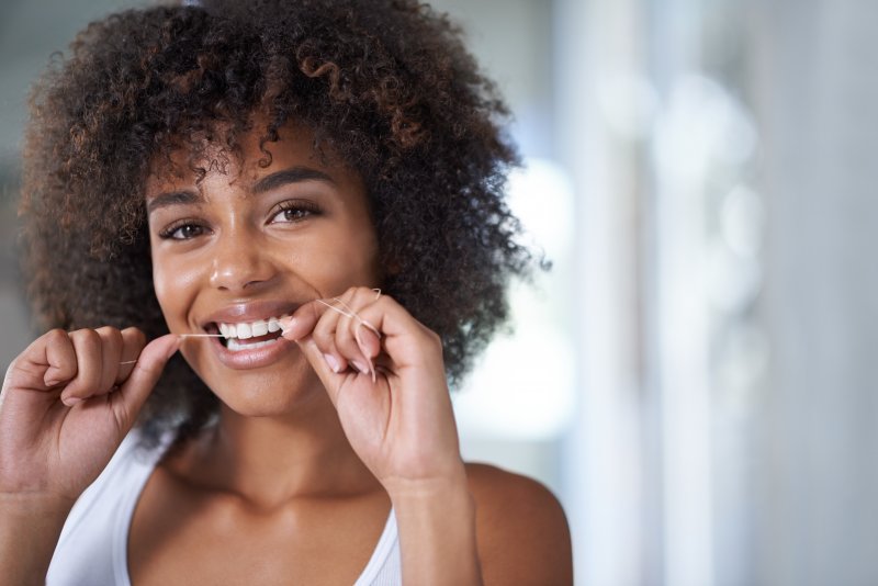 a woman flossing and smiling in Chelsea