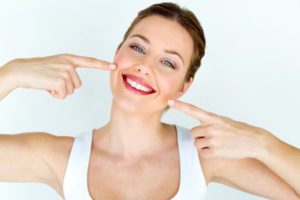 a person pointing toward their smile
