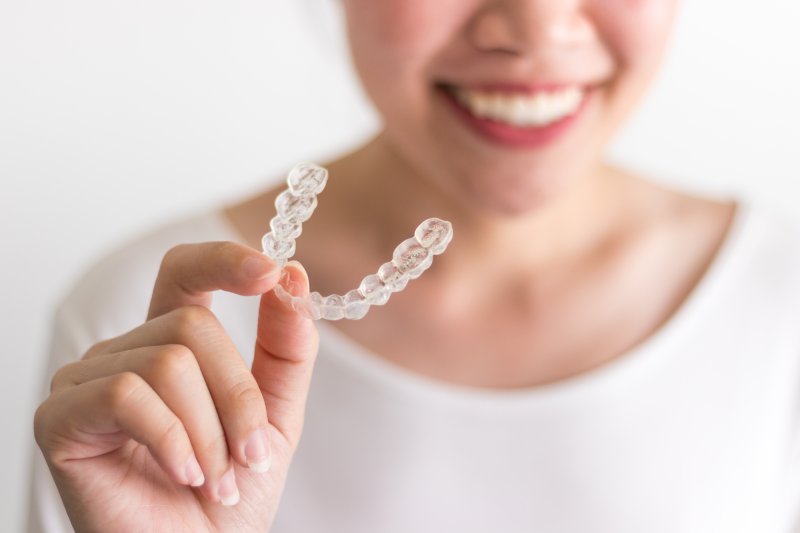 person holding clear aligner trays