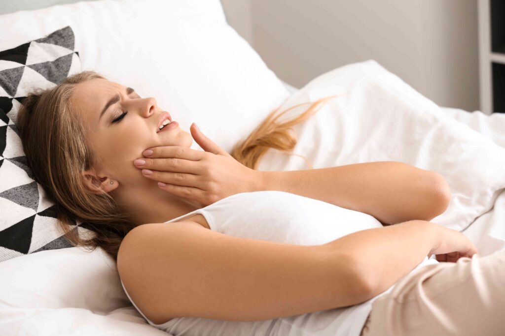 Woman in bed with tooth pain